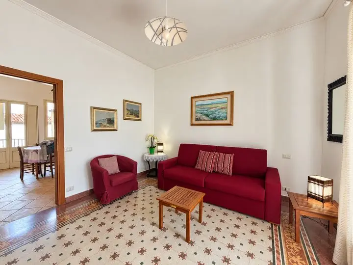 Living room with red sofa and patterned cement tiles, Casa del Duomo, Cefalù