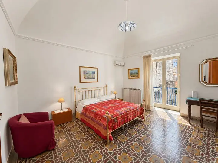Camera matrimoniale con letto in ottone e portafinestra, Casa del Duomo a Cefalù