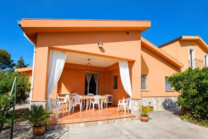 Covered veranda with dining table and curtains, Villa dei Limoni, Cefalù